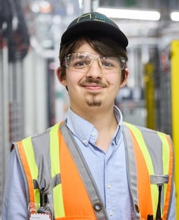 Employé en gilet de sécurité dans un environnement industriel.