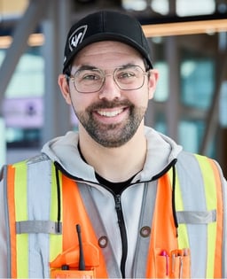 Personne en gilet de sécurité réfléchissant et casquette dans un environnement intérieur.