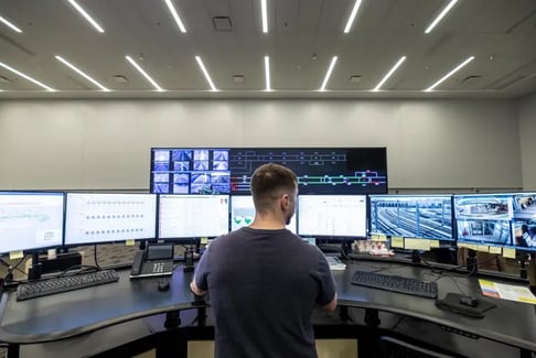 Centre de contrôle moderne avec opérateur et écrans de surveillance.