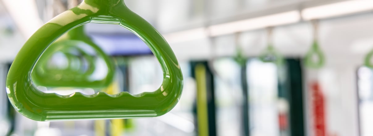 Poignées vertes suspendues dans un véhicule de transport en commun.