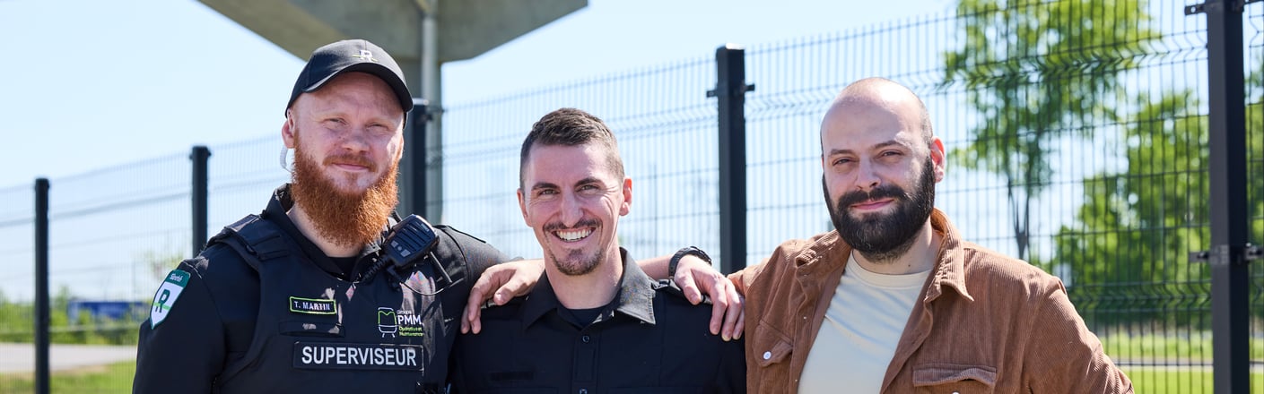 Trois agents en uniforme, dont deux inspecteurs, posent dans un lieu intérieur bien éclairé.