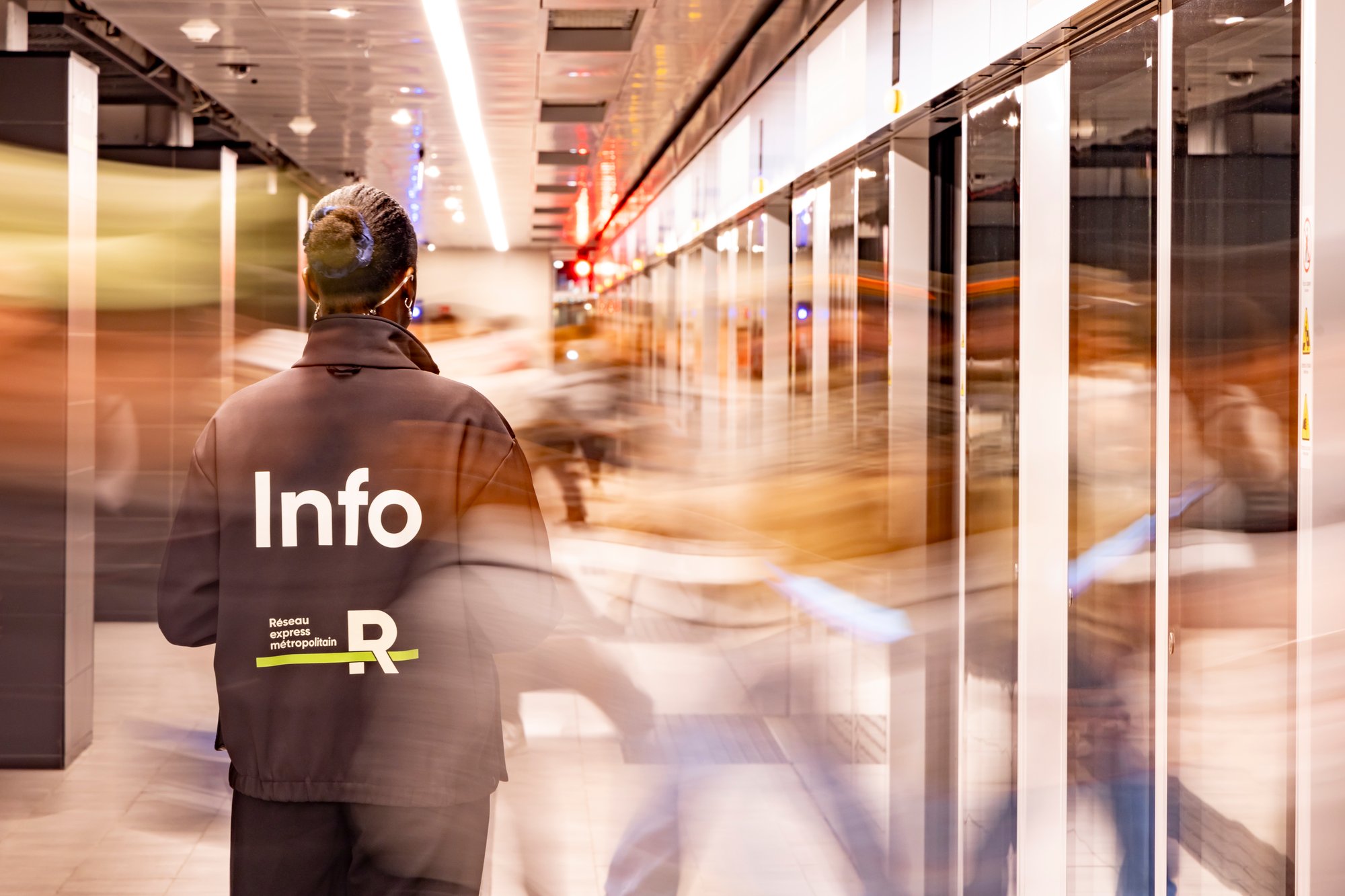 Agent de station de dos au milieu d'une foule