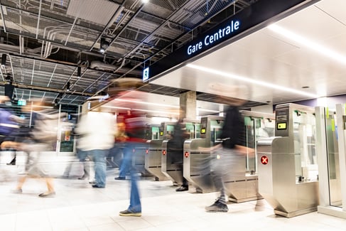 Entrée de la Gare Centrale avec tourniquets et passagers en transit.