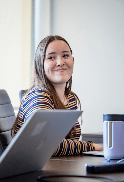 Femme assise à un bureau souriant à un collègue